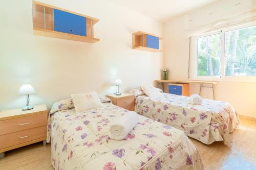 a bedroom with two beds and a window at La Torre: casa perfecta con piscina privada in Pobla de Montornés
