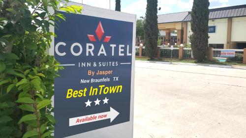 a sign for a centennial inn and suites next to a building at Coratel Inn & Suites by Jasper New Braunfels IH-35 EXT 189 in New Braunfels