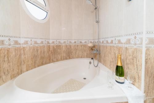 a white bath tub with a bottle of champagne at La Torre: casa perfecta con piscina privada in Pobla de Montornés