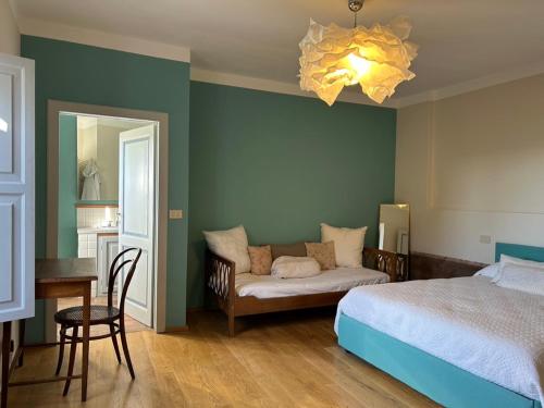 een slaapkamer met een bed, een bank en een kroonluchter bij Casa Stella a due passi da Orta in Ameno