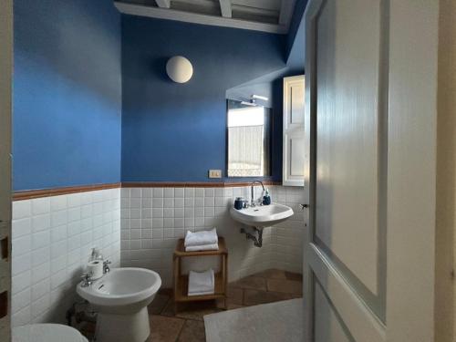 een blauwe badkamer met een toilet en een wastafel bij Casa Stella a due passi da Orta in Ameno