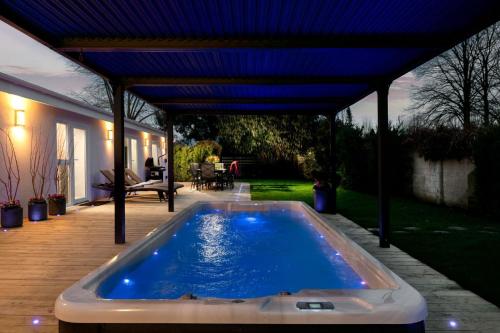 a swimming pool under a pergola in a backyard at Paisley Cottage in Sandwich