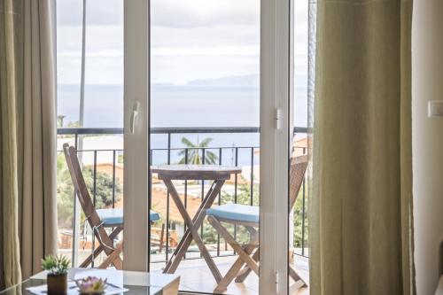 a room with a balcony with a table and chairs at Sea View Apartment in Santa Cruz