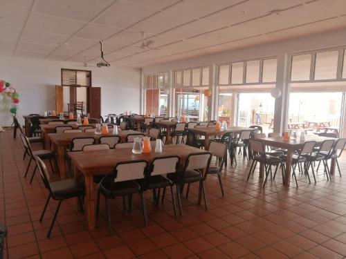 uma sala com mesas e cadeiras num restaurante em TRASHAVEN - Seaside Haven Backpackers em Durban