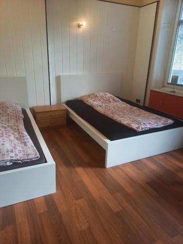 2 Betten in einem Zimmer mit Holzböden in der Unterkunft Paulibude in Hamburg