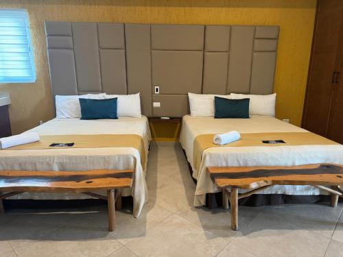 two beds sitting in a room with sidx sidx sidx at Suites Valentina in Puerto Morelos