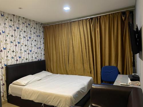 1 dormitorio pequeño con 1 cama y 1 silla en Hotel Global Subang, en Subang Jaya