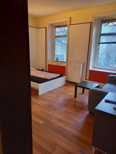 ハンブルクにあるパウリブーダのベッド1台とソファが備わる小さな客室です。
