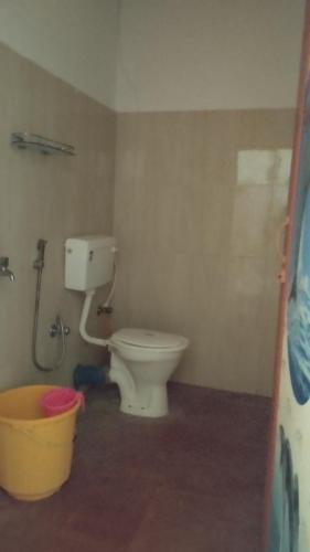 a bathroom with a toilet and a bucket at Blue Whale Resort and Restaurant in Neil Island