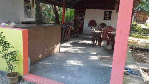 a patio with a bar and tables and chairs at Blue Whale Resort and Restaurant in Neil Island