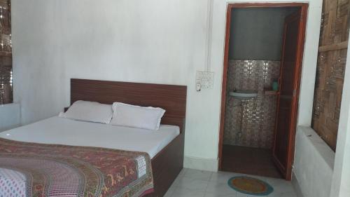 a small bedroom with a bed and a shower at Blue Whale Resort and Restaurant in Neil Island