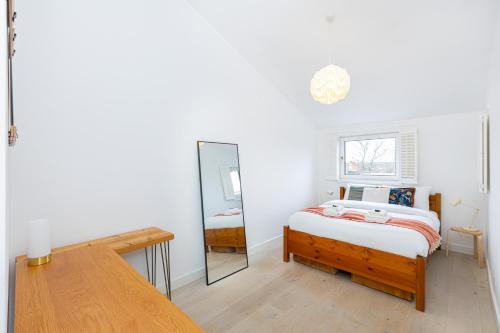 um quarto com uma cama e um espelho em Stylish 1BR apt, 7min Archway Tube & Holloway Rd em Londres