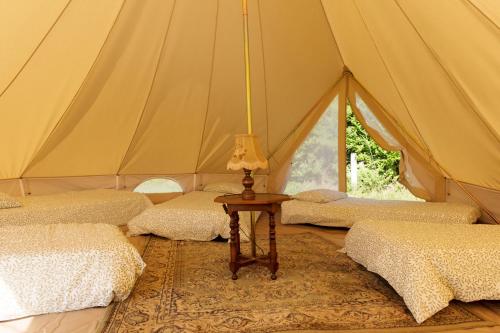 a tent with four beds and a table with a lamp at Aparra Surfcamp Capbreton in Capbreton