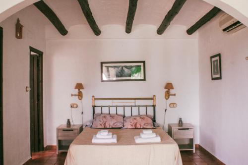 1 dormitorio con 1 cama con 2 mesas y 2 toallas en Hotel Rural Alqueria de los lentos en Nigüelas