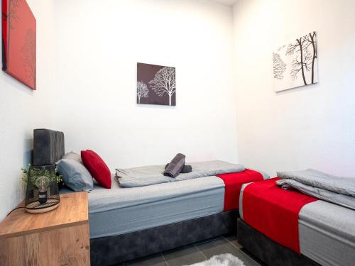 2 camas en una habitación con rojo y gris en SR24-Stillvolles gemütliches Apartment 1 in Recklinghausen, en Recklinghausen