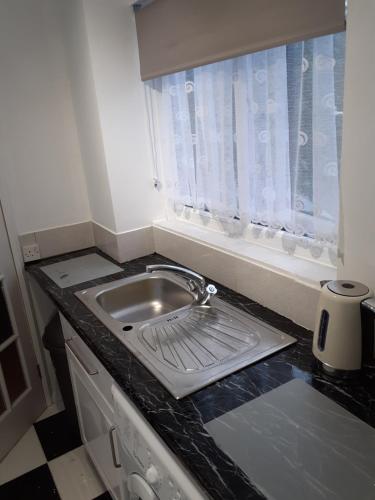 a kitchen counter with a sink and a window at Heart of Deptford in London