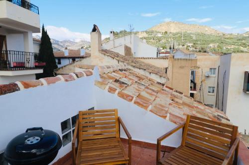 2 Stühle auf dem Balkon eines Hauses mit Aussicht in der Unterkunft Calle Villa Baja Castril in Castril