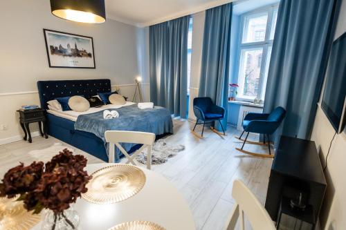 um quarto com uma cama, uma mesa e cadeiras em Apartament Hampton em Toruń