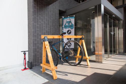 a bike on a stand in front of a building at Shizutetsu Hotel Prezio Numazu in Numazu