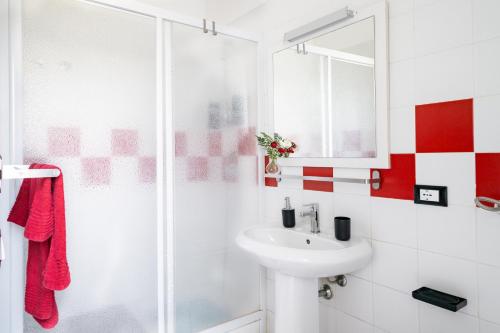 een witte badkamer met een wastafel en een douche bij !!! 2 MIN DALLA SPIAGGIA !!! - Casa Vacanze Coralli in Sciacca