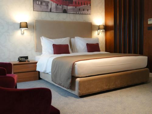 um quarto com uma cama grande num quarto de hotel em Ramada Hotel & Suites by Wyndham Erbil 32 Park em Arbil