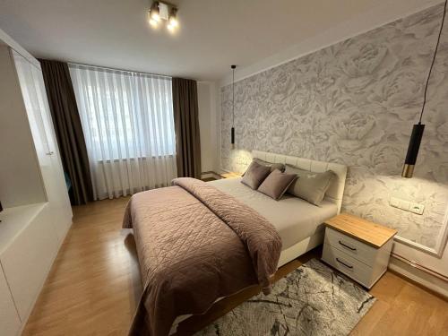 een slaapkamer met een bed en een muurschildering bij Apartman Mona in Teslić