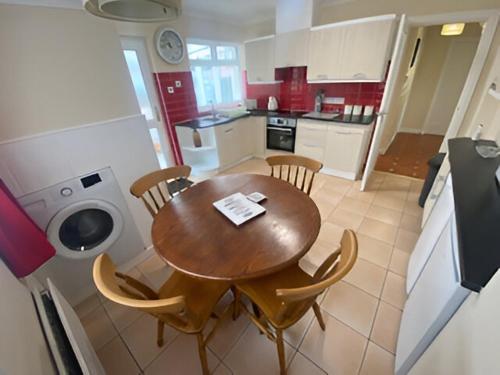 uma cozinha com uma mesa de madeira e cadeiras numa cozinha em Bungalow Three Bedroom The Park Onchan Isle of Man em Onchan