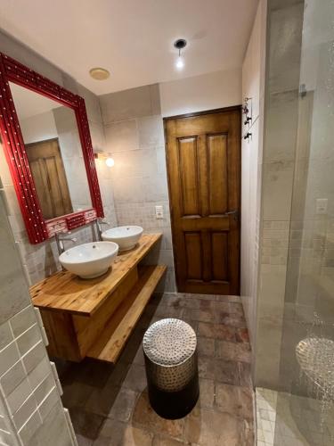 La salle de bains est pourvue de 2 lavabos et d'un miroir. dans l'établissement Le Patio Carreterie - Maison chaleureuse avec Jacuzzi Extérieur Privatif - Primée pour sa déco, à Avignon