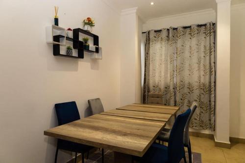 a dining room with a wooden table and chairs at Elegantly furnished one-bedroom -Avant Garde in Accra