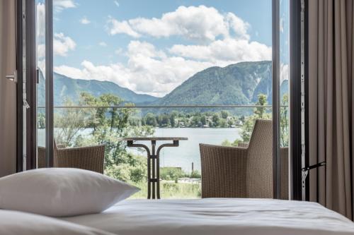 a bedroom with a bed and a view of a lake at Seehotel Restaurant Lackner in Mondsee