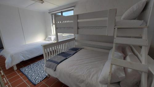a bedroom with two bunk beds and a ladder at flip flops in Agulhas