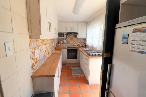 a kitchen with white cabinets and an orange tile floor at flip flops in Agulhas