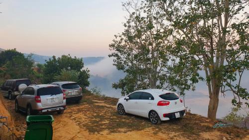 three cars parked on the side of a dirt road at Tuyên Chiến Home - Nhà Gỗ in Ấp An Kroët