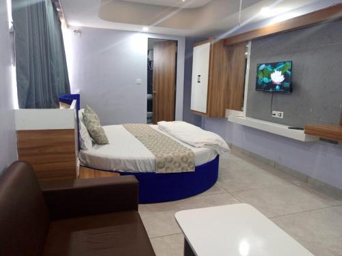 um quarto com uma cama e uma televisão na parede em Hotel Red Blue,Ahmedabad em Naroda