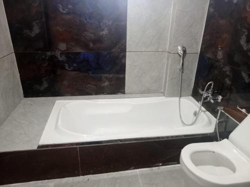 Hotel Red Blue,Ahmedabad في Naroda: حمام مع حوض استحمام ومرحاض