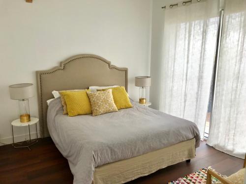 - une chambre avec un grand lit et des oreillers jaunes dans l'établissement Appartement entre mer et montagne, à Ustaritz