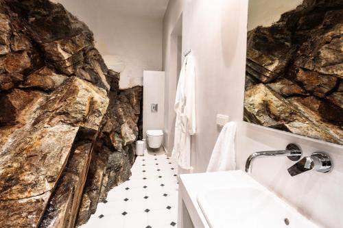 bagno con grande parete in pietra di Oikia Classic House a Kavala