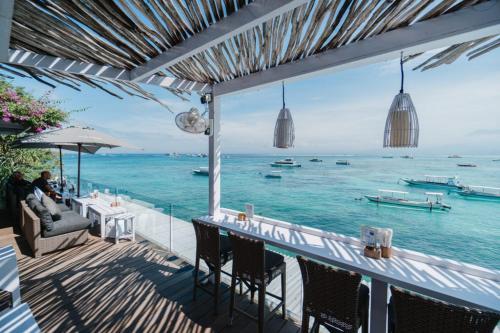 a bar with a view of the ocean with boats at Best Choice Nusa Lembongan in Nusa Lembongan