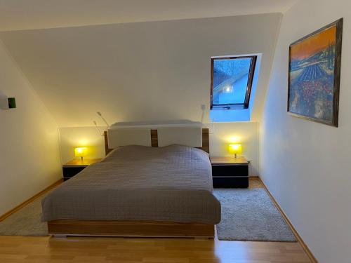 トロイスドルフにあるFeWo LaChristina Köln-Bonn-Siegburgのベッドルーム1室(ベッド1台、ランプ2つ、テーブル2台付)