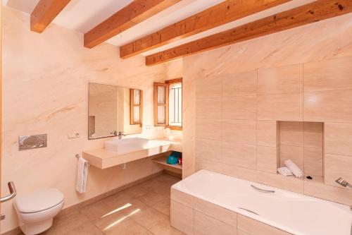 y baño con aseo, lavabo y bañera. en Villa Els Baladres, en Port de Pollença (Puerto Pollensa)