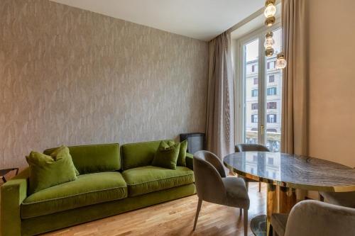 - un salon avec un canapé vert et une table dans l'établissement Residenza Pierret, à Rome