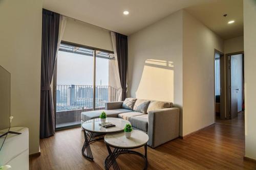 un soggiorno con divano e tavolo di Luxury 2 Bedrooms Condo Checkin 24h Infinity Pool 360 a Bangkok