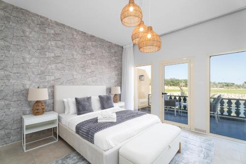 1 dormitorio con cama blanca y pared de piedra en Nasma Luxury Stays - Exquisite 4BR Villa, with a Private Pool, en Ras al Khaimah