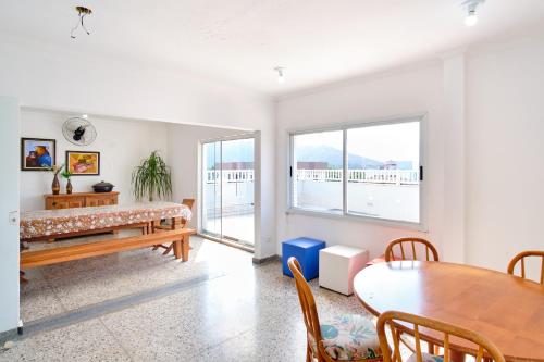 a living room with a table and chairs and a dining room at PS5: Aproveite Ubatuba! Apto Completo & Bem Localizado in Ubatuba
