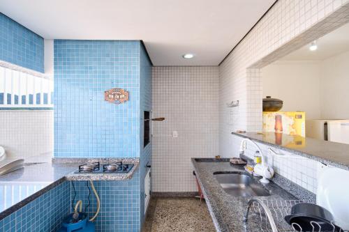 a kitchen with blue tiles and a sink at PS5: Aproveite Ubatuba! Apto Completo & Bem Localizado in Ubatuba