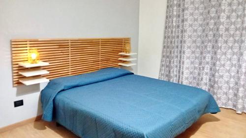 um quarto com uma cama azul e uma janela em Messina’s apartment em Messina
