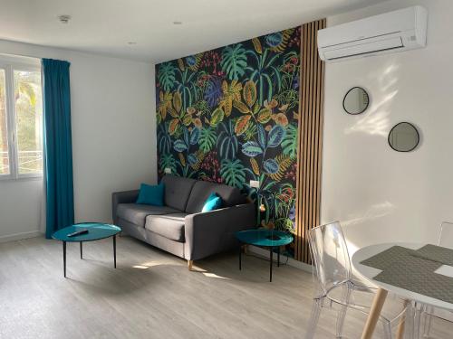 a living room with a couch and a colorful wall at Villa 418 in Saint-Raphaël
