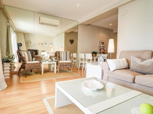 a living room with a couch and a table at Bel Apartment by Hello Homes Sitges in Sitges