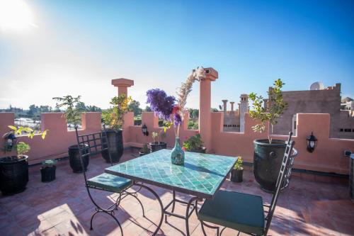 a patio with a table and chairs on a roof at Riad Kenza in Marrakech