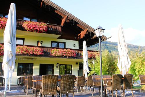 a group of chairs and umbrellas in front of a building at DEVA Hotel-Restaurant Fischerwirt inklusive Chiemgau Card in Ruhpolding